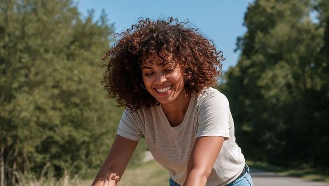 Joyful woman cycling through scenic outdoor path in nature
