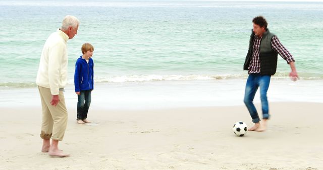 Multigenerational family playing soccer on sandy beach near ocean. Ideal for illustrating family bonding, leisure activities, summer vacations, and healthy lifestyle.