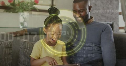 Father and daughter sharing tablet on couch, smiling with glowing digital hud overlay