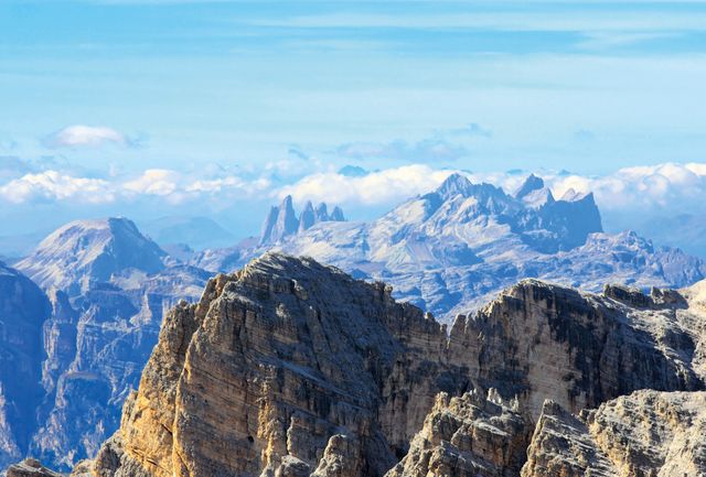 This striking image showcases tall, rugged mountain peaks against a backdrop of a clear blue sky. Ideal for use in travel and adventure content, outdoor activity advertisements, or nature-themed website imagery. This photo provides a sense of grandeur and exploration, perfect for inspiring outdoor enthusiasts and promoting mountainous destinations.