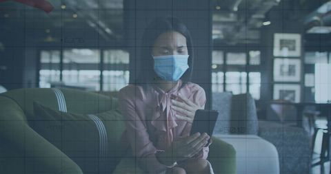 Masked Businesswoman Using Smartphone with Financial Data Overlay