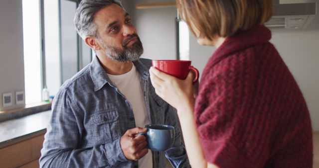 Happy diverse couple in kitchen together drinking coffee and talking - Download Free Stock Photos Pikwizard.com