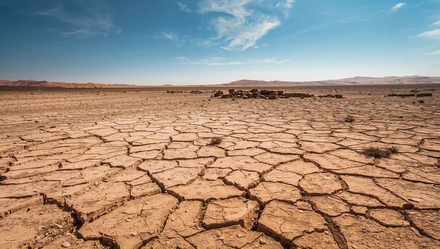 Cracked desert clay spreading across parched playa basin under clear blue sky