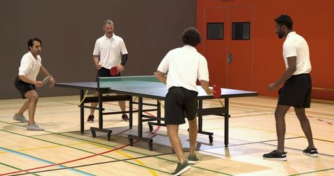 Diverse Male Players Competing in Doubles Table Tennis Match