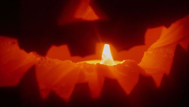 Glowing jack-o'-lantern closeup with flickering candle