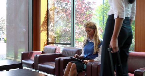 Young woman engaged in tablet work in modern waiting area