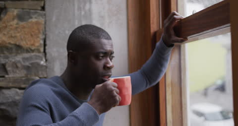 Contemplative Man Drinking Coffee by Window