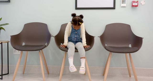 Little Girl Sitting on Waiting Room Chair with Head Down - Download Free Stock Images Pikwizard.com