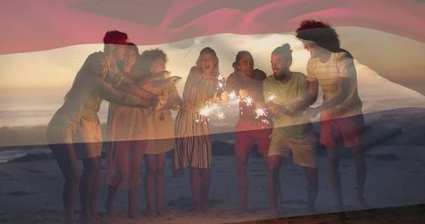 Joyful Group Holding Sparklers on Beach at Twilight
