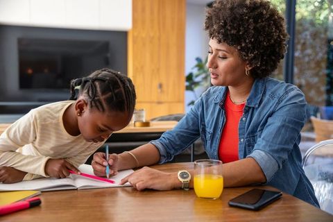 Mother Supporting Daughter with Learning at Home Kitchen Table