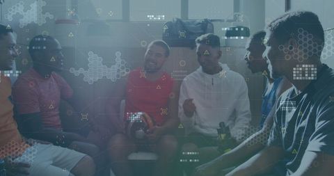 Diverse football players analyzing data in locker room