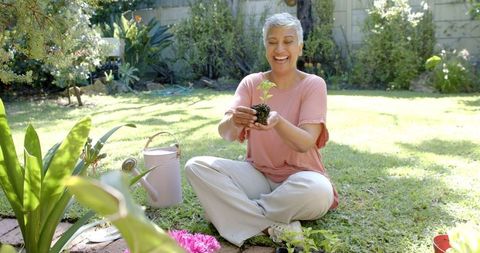 Cheerful Senior Woman Gardening Outdoors in Sunlit Yard