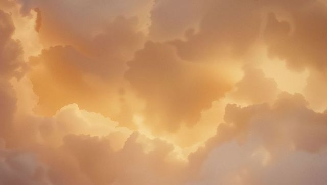 Golden clouds illumined at sunset creating ethereal sky