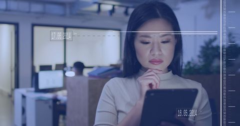 Asian Businesswoman Using Digital Tablet with Data Overlay Office Setting