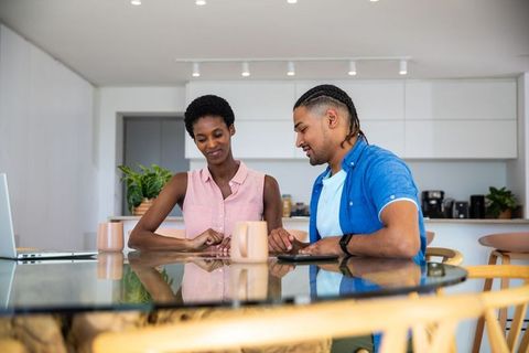 Diverse Couple Appreciating Ring Gift Sitting in Modern Kitchen
