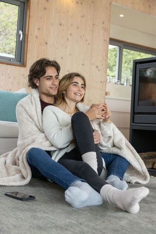 Couple Enjoying Cozy Moment in Rustic Cabin with Blanket