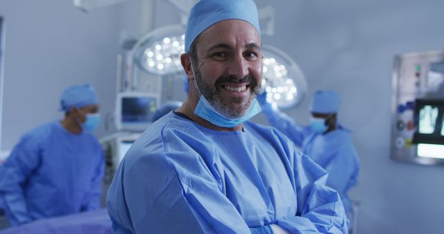 Portrait of caucasian male surgeon standing in operating theatre smiling to camera. medicine, health and healthcare services.