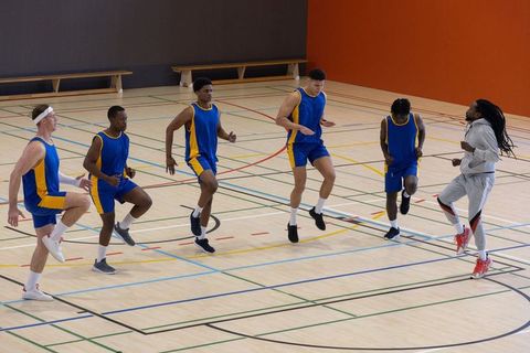 Basketball Team Performing High-Knee Drill on Indoor Court
