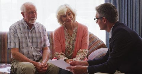 Senior Couple Discussing Financial Planning with Advisor at Home