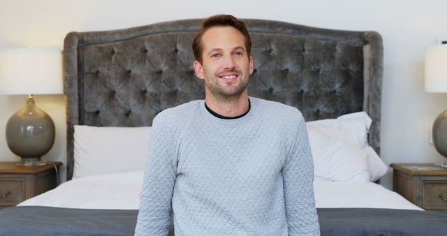 Smiling Man Sitting on Bed in Cozy Bedroom - Download Free Stock Images Pikwizard.com