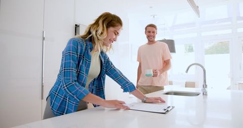 Couple Reviewing Documents in Modern Kitchen