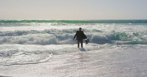 Businessman Walking into Ocean with Briefcase - Download Free Stock Images Pikwizard.com