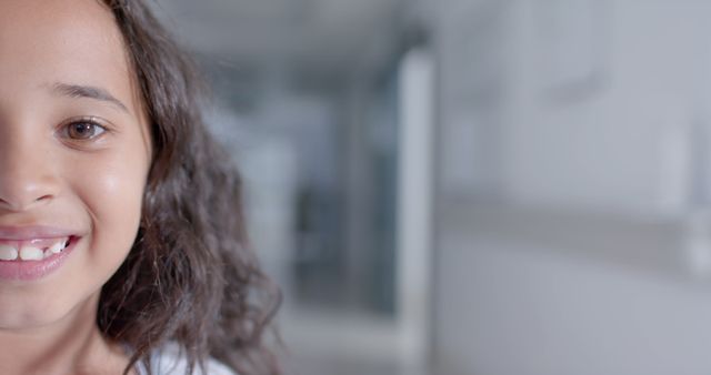 Close-up of Smiling Young Girl with Curly Hair in Bright Indoor Environment - Download Free Stock Images Pikwizard.com