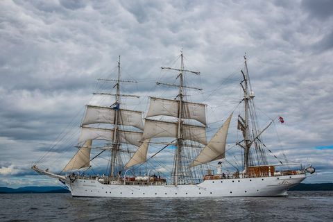 Majestic tall ship sailing under cloud-filled sky