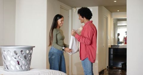 Couple Enjoying Domestic Chores in Cozy Modern Bedroom