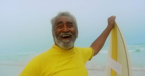 Joyful Senior Man Enjoying Surfing at Beachside