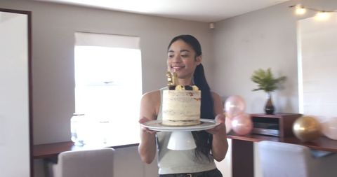 Young Woman Celebrating Birthday with Festive Cake in Living Room