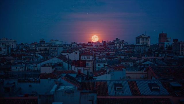 Full Moon Glowing Orange Over Urban Rooftops Nightscape