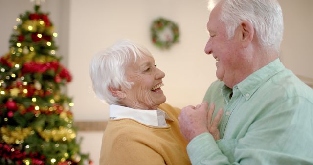 Happy senior caucasian couple dancing next to christmas tree at home, slow motion - Download Free Stock Photos Pikwizard.com