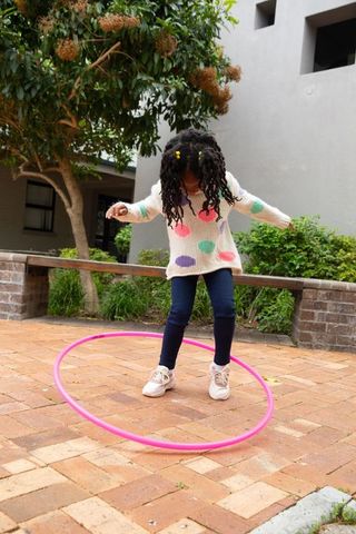 Vibrant childhood fun in brick courtyard with hula hoop