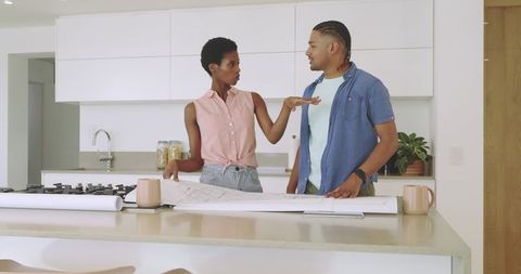 Diverse Couple Discussing Home Renovation Plans in Modern Kitchen