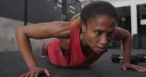 African American Woman in Intense Push-up Exercise in Gym
