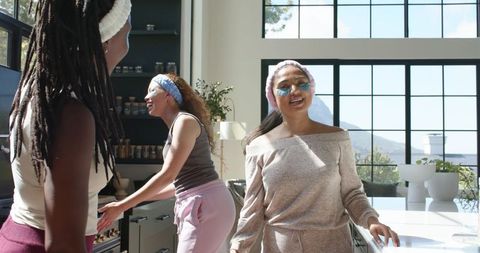 Sunlit self-care morning featuring african american women laughing in modern kitchen