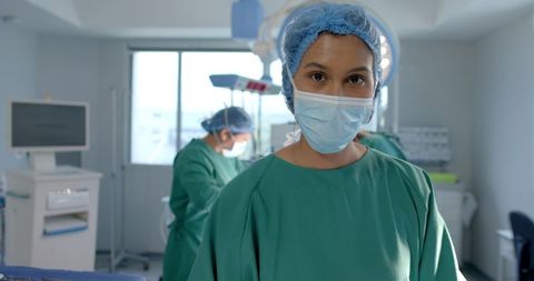 Focused Female Surgeon in Operating Room with Teamwork in Background - Download Free Stock Images Pikwizard.com