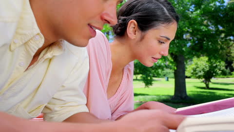 Couple Relaxing and Reading Books in Countryside Park