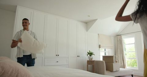 Couple arranging new bedroom after move in bright daylight