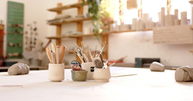 Brushes, pottery tools and clay on desk in pottery studio. Pottery, ceramics, handmade, local business, hobbies and craft.
