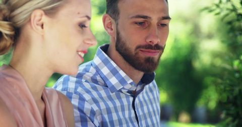 Friends Enjoying Conversation in Sunny Garden Restaurant