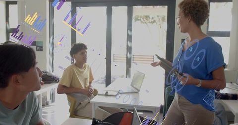 Teacher presenting interactive data overlays to students using laptops and tablets in classroom