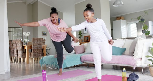 Mother and daughter practicing yoga on pink mats in living room, creating healthy and fun bonding moments. Ideal for promoting family workouts, healthy living, indoor fitness, and quality time.