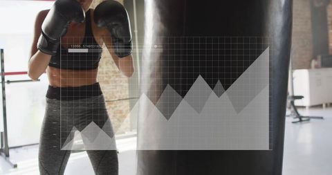 Female boxer training on heavy bag with performance data overlay in sunlit gym