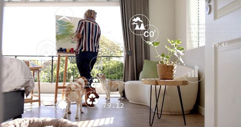 Creative artist painting on canvas in sunlit living room with dogs, plants, balcony view
