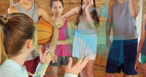 Basketball coach guiding teen athletes in gym setting