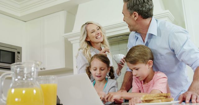 Happy Family Enjoying Breakfast While Using Laptop in Kitchen - Download Free Stock Images Pikwizard.com