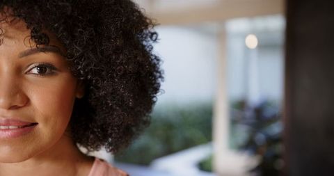Close-Up Portrait of Smiling Woman with Curly Hair and Serene Expression
