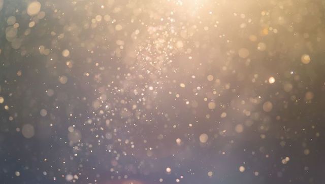 Abstract Shimmering Dust Particles in Warm Golden Light